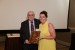 Dr. Nagib Callaos, General Chair, giving Ms. Laurie Corrigan a plaque "In Appreciation for Delivering a Great Keynote Address at a Plenary Session."